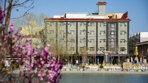 Un hôtel doté d’une architecture moderne, caractérisé par une entrée imposante et une grande enseigne affichant des caractères chinois.