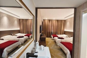 Une chambre d’hôtel avec deux lits, un grand miroir, une table de chevet et un sol recouvert de moquette.