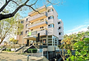 A multi-story hotel with a modern design, featuring balconies, a ground-level restaurant, and a staircase leading to the entrance. - Brotnjo (Citluk)