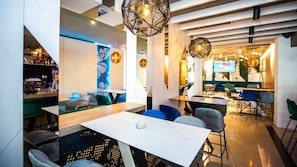 A modern restaurant with a bar area, seating with blue and grey chairs, and geometric wall decor. - Brotnjo (Citluk)