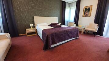 Une chambre d’hôtel avec un grand lit, un bureau, une chaise et un canapé.