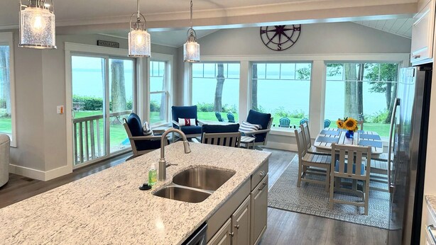 A kitchen with a granite countertop, stainless steel sink, and pendant lighting. - Lakefront Getaway: The Blue Bungalow on Seneca Lake (Torrey)