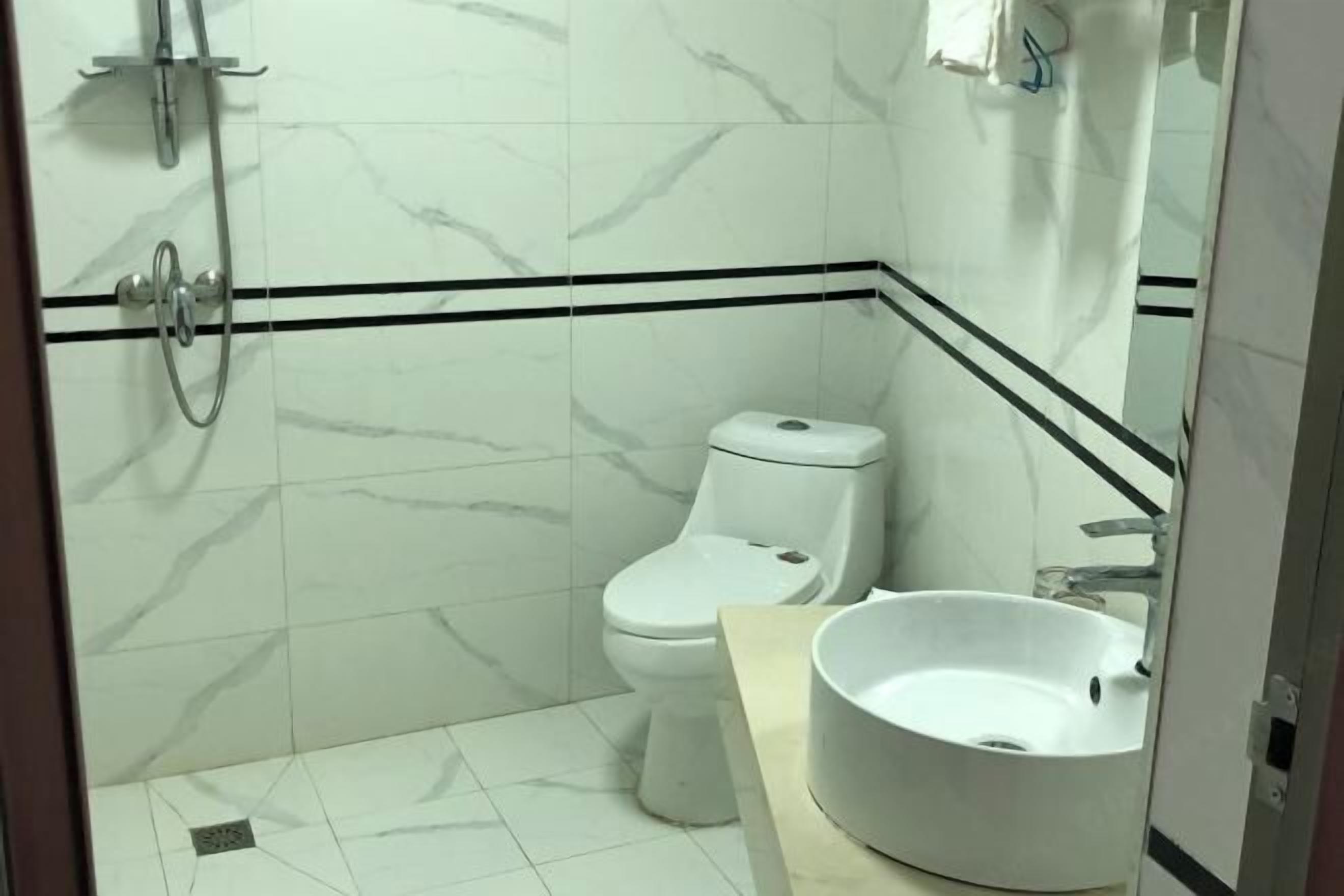 A bathroom with a toilet, a sink, and a shower.
