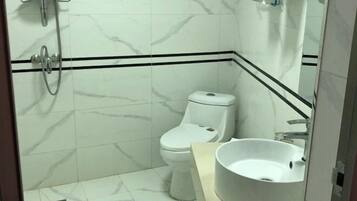 A bathroom with a toilet, a sink, and a shower.