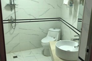 Un baño con inodoro, lavamanos y ducha.