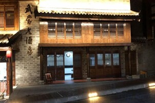 Un edificio tradicional con techo de tejas, puertas de madera y fachada de ladrillo.