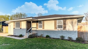 A two-story house with a front porch, a garage, and a well-maintained lawn. - Great location, Close to everything in Bentonville (Bentonville)