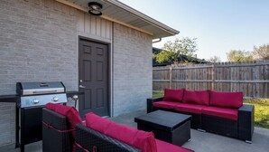An outdoor patio with a grill, wicker furniture, and a wooden fence. - Great location, Close to everything in Bentonville (Bentonville)