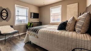 A bedroom with a bed, a chair, a TV, and a ceiling fan. - Great location, Close to everything in Bentonville (Bentonville)