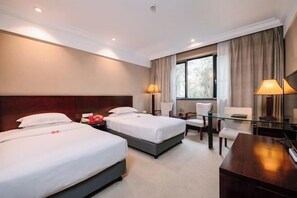 A hotel room with two beds, a desk, a chair, and a large window with curtains. - Taizhou Chunlan Guest House Old Street Branch (Taizhou)