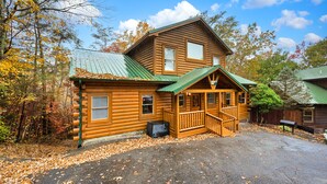 A log cabin with a green metal roof, a porch, and a small front yard. - Fall Break Special!•Hot Tub•Game Room•Sleeps 22•3600 sq ft •Pigeon Forge (Pigeon Forge)
