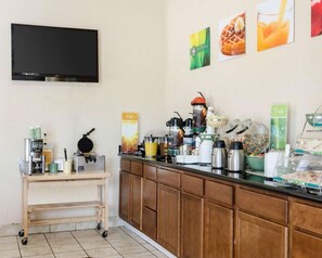 A breakfast bar with coffee machines, a waffle maker, and a variety of food items. - Quality Inn Louisville MS (Louisville)