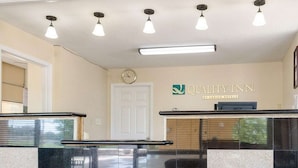A reception area with a reception desk, a clock, and a sign that reads 'QUALITY INN.' - Quality Inn Louisville MS (Louisville)