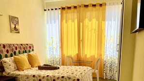 A hotel room with two beds, a chair, a table, and a TV. - Hotel María Bonita Higüey,  room 301 Family property centrally located (Higüey)