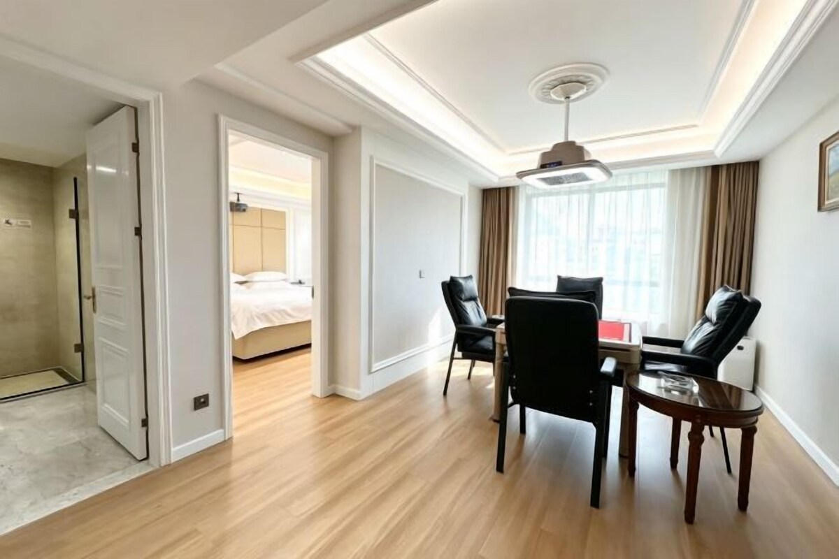 A hotel room with a bed, a desk, two chairs, and a small table.