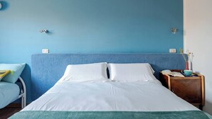 A hotel room with a large bed, a bedside table with a lamp, and a small wooden nightstand. - Peaceful Apartment Surrounded by Nature – Quiet Location Minutes from Assisi (Pian della Pieve)