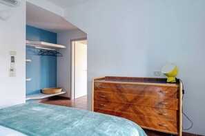 Un dormitorio con una cama, un aparador de madera, un espejo y una lámpara.
