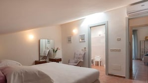 A bedroom with a bed, a chair, a vanity, and a mirror. - Il Sentiero Apartment, sourrounded by greenery (Pian della Pieve)
