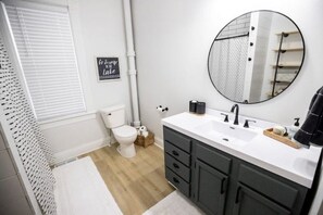 Main floor bath with large vanity and full size tub and tiled shower