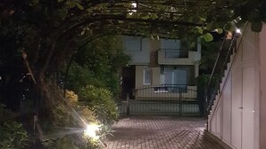 Un chemin pavé mène à un bâtiment dont l’entrée est protégée par un portail.