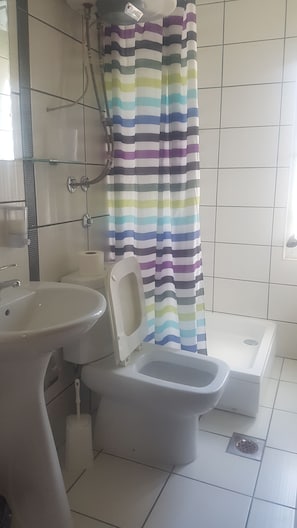 Un baño con inodoro, bidé y lavamanos.