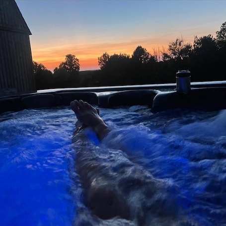 Outdoor spa tub. The Ridge Adventure Center rustic pet friendly tiny cabin, outdoor shower stage
