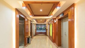 A hallway with wooden walls and a marble floor, leading to a balcony with a view. - Lanmei Riverside Holiday Hotel (Jinghong)