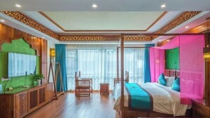 A room with a wooden floor, a bed with a green headboard, a wooden cabinet, and a window with curtains. - Lanmei Riverside Holiday Hotel (Jinghong)