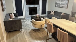 A modern living room with a sofa, a coffee table, and a dining area with chairs. -  HOT TOB HEATED POOL HOUSE, MINUTES FROM CLEARWATER BEACH (Clearwater)