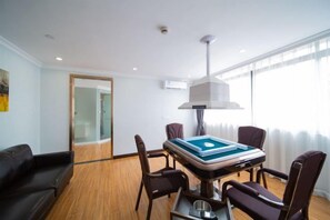 A room with a pool table, a sofa, and a dining table with chairs.