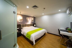 Ein Hotelzimmer mit Bett, Nachttischen, Schreibtisch und Stuhl.