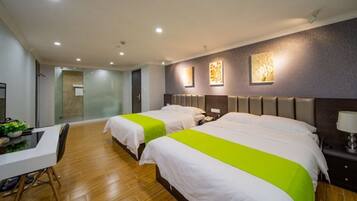 A hotel room with two beds, a desk, and a shower area.
