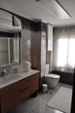 A modern bathroom with a marble vanity, a toilet, and a shower area. - Apartment in a house with garden, pool and barbecue, 10 minutes from Pontevedra (Vilaboa, Pontevedra)
