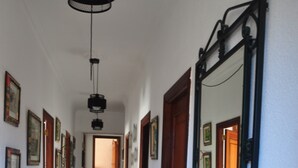 A hallway with a wooden bench, a mirror, and a rug leading to a door. - Barranqueiro House (Vilaboa, Pontevedra)
