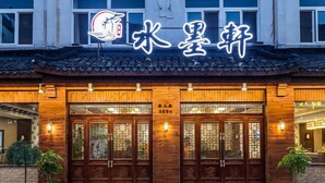 A traditional Chinese restaurant with wooden doors and a sign above.