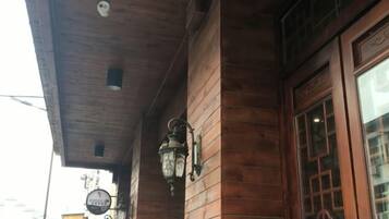 Fachada de madera con diseño tradicional, que incluye una puerta de madera grande y una ventana pequeña.