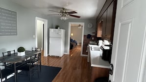 Una cocina amplia con suelo de madera, ventilador de techo y refrigerador.