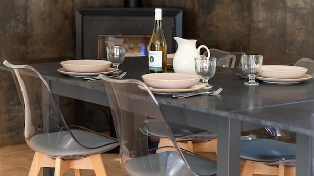 A dining table with clear chairs, a white pitcher, wine bottle, and plates. - Large gîte in a riverside setting on the banks of the Cher river (Azay-sur-Cher)