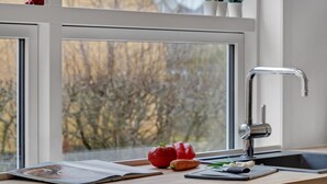 A kitchen counter with a cutting board, vegetables, and a magazine. - Cozy home in Nykøbing M with WiFi (Nykøbing M)
