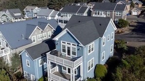 Um bairro residencial com várias casas de dois andares, com varandas frontais marcantes e uma mistura de telhados em gable e planos.