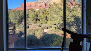 A room with a large window offering a view of red rock formations and trees. - Magnificent Sedona Redrock Views; 7-Min Walk to Uptown;Single-Level;Eco-Friendly (Sedona)