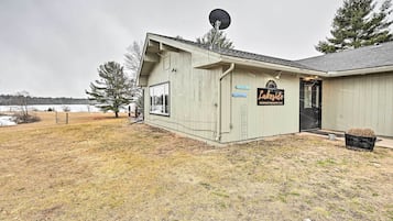 A lakeside building with a satellite dish, a sign reading "Lakeside Waterfront Restaurant & Bar," and a small outdoor seating area.