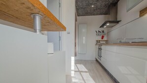 A modern kitchen with white cabinetry, a wooden countertop, and a stainless steel range hood. - La Louvière - JEUGNY - Gîte (JEUGNY)