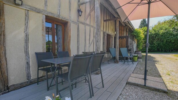 A wooden building with a patio area featuring outdoor seating and a pergola. - La Louvière - JEUGNY - Gîte (JEUGNY)