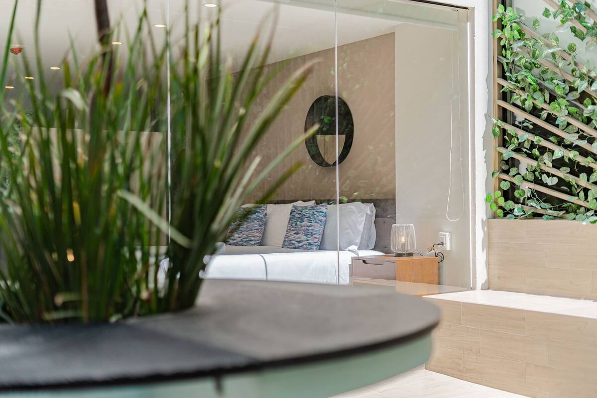 Un dormitorio moderno con una cama, una mesita de noche y un adorno circular en la pared.