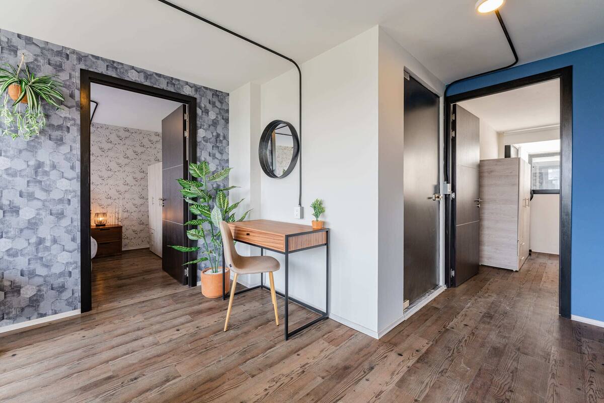 Un interior moderno con un escritorio de madera, una silla y plantas en macetas.