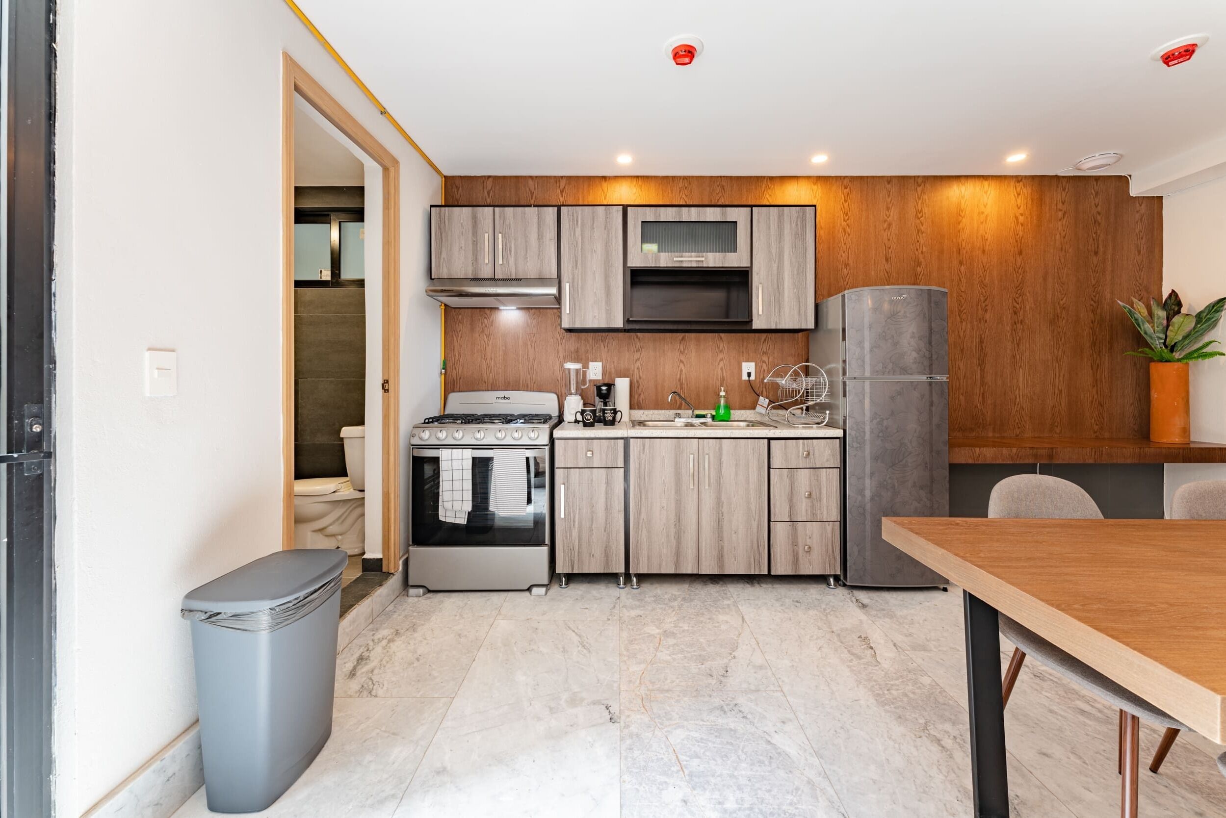 A modern kitchen with a built-in oven, microwave, and refrigerator.