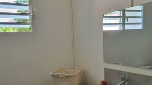 A compact laundry room with a washing machine, a sink, and a mirror. - Property in peaceful, central countryside (Ducos)