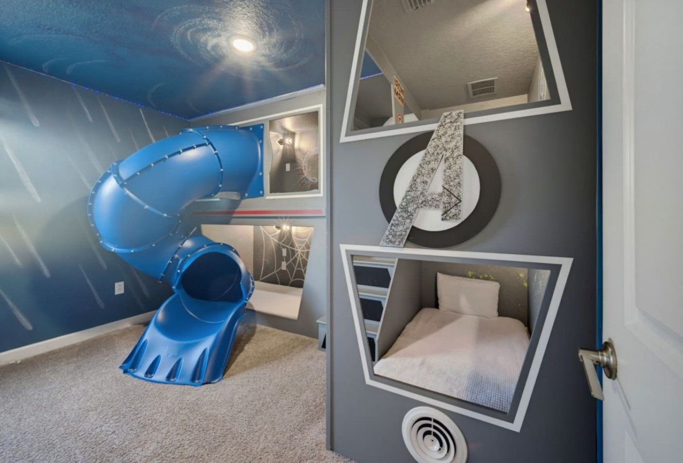 Een kinderspeelruimte met een glijbaan en een wandbed.