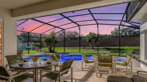 An indoor patio with a view of a backyard pool, outdoor furniture, and a glass ceiling. - The Marvel Mansion 5BR Pool Home Near Disney World (Four Corners)